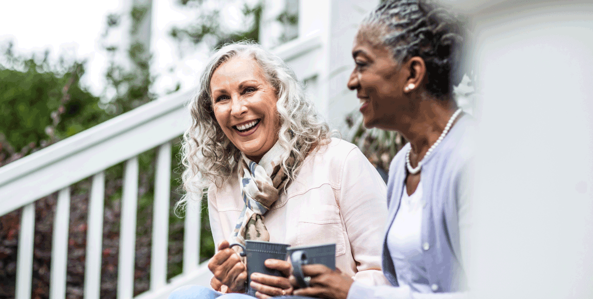 Two happy women enjoying coffee together